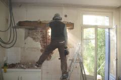 Michael knocks through the outside kitchen wall, light breaks through into the kitchen
